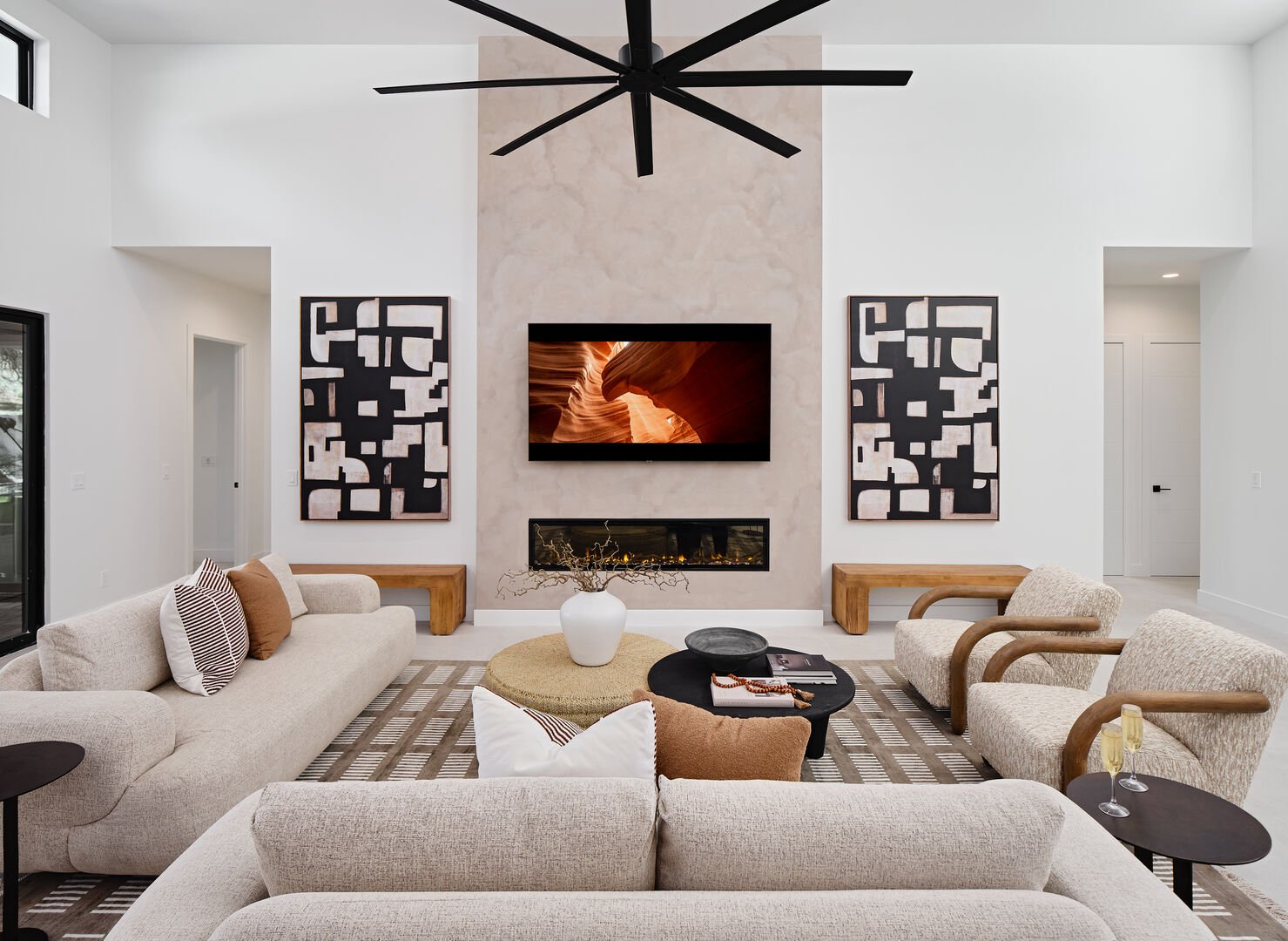 Grand open-concept living space with designer decor, featuring a fireplace and Smart TV.