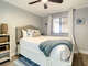 Queen bed with ceiling fan above.