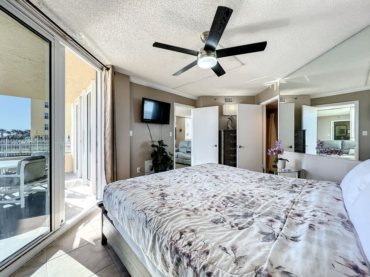 Cozy king size bed with TV in room. Oceanfront view. Equipped with ceiling fan.