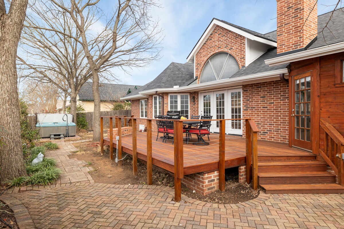 Expansive wooden deck, an ideal spot for outdoor entertainment or a peaceful evening, with the hot tub just steps away
