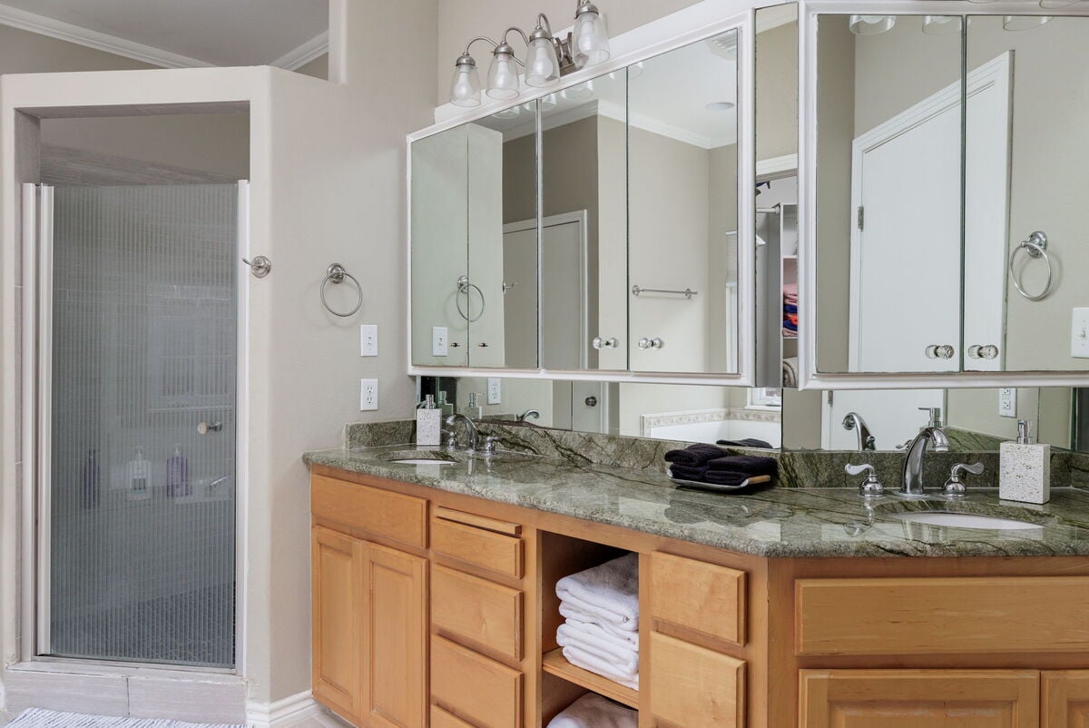 Pamper yourself in the master bathroom, boasting a spacious vanity with dual sinks, ample mirror space, and a luxurious walk-in shower.