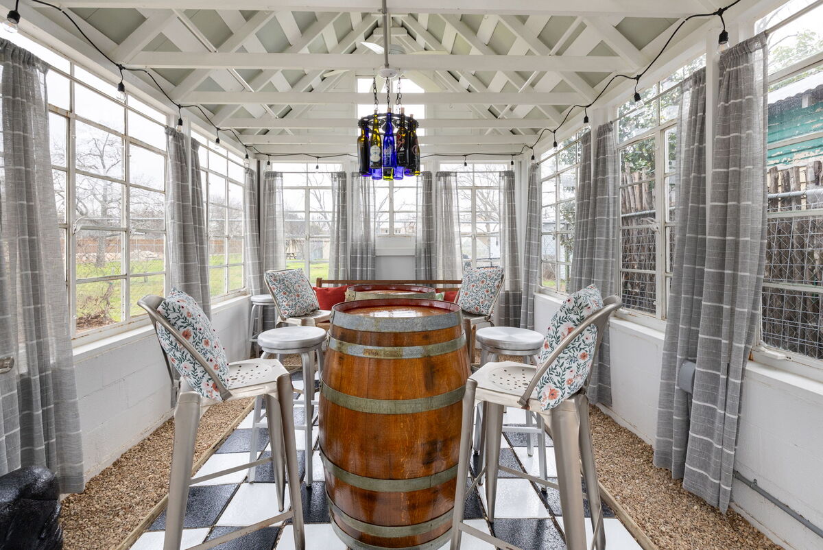 Gather with loved ones in the greenhouse, a charming space that blurs the line between indoors and outdoors, perfect for enjoying meals in any weather.