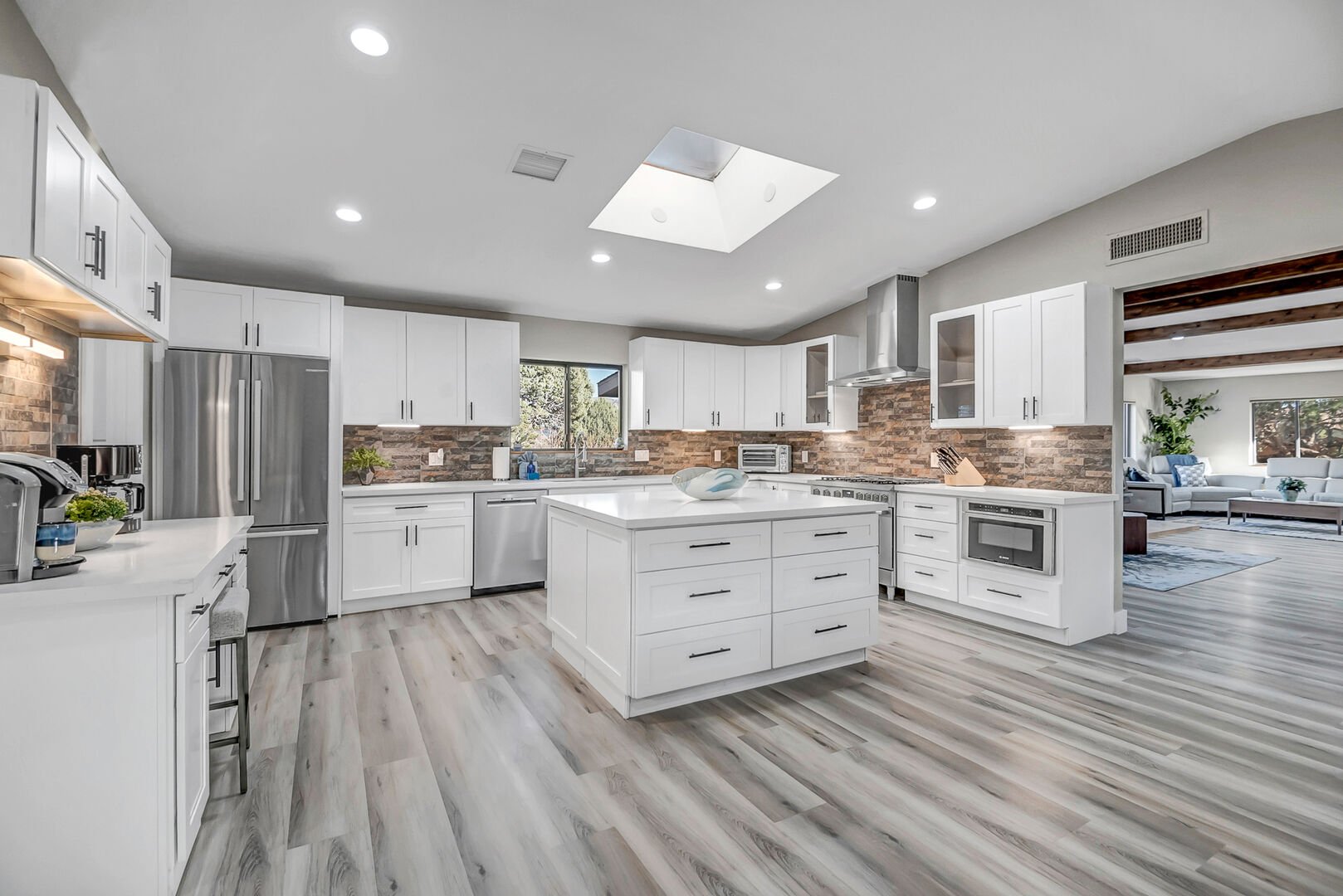 Completely remodeled kitchen with high-end stainless steel appliances, including a 6-burner gas stove, and large kitchen island