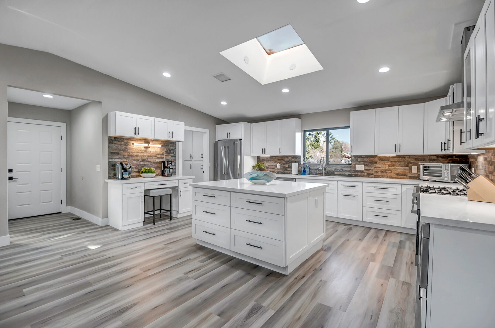 Completely remodeled kitchen with high-end stainless steel appliances, including a 6-burner gas stove, and large kitchen island