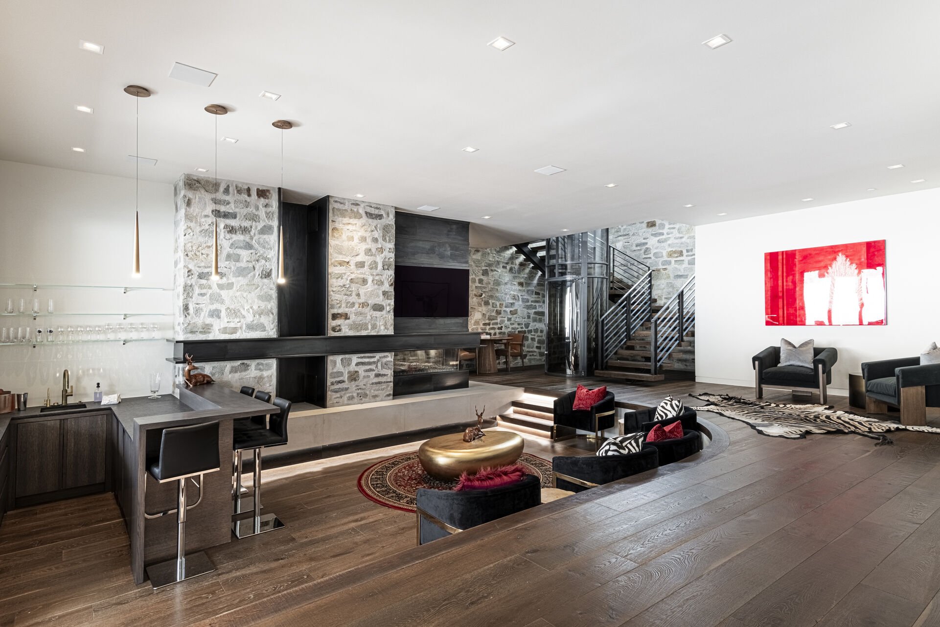 Lower level sunken conversation room with a gas fireplace, Smart TV and wet bar
