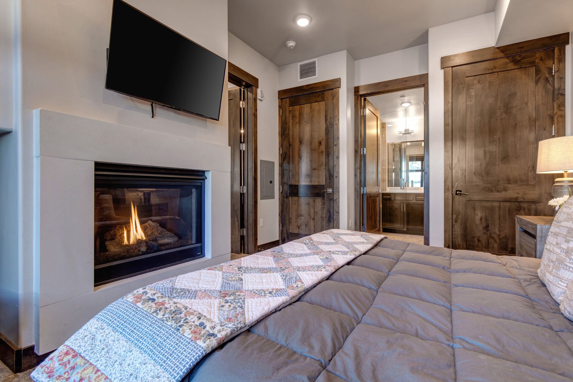 Master bedroom with king bed, smart TV, gas fireplace, and ensuite bathroom