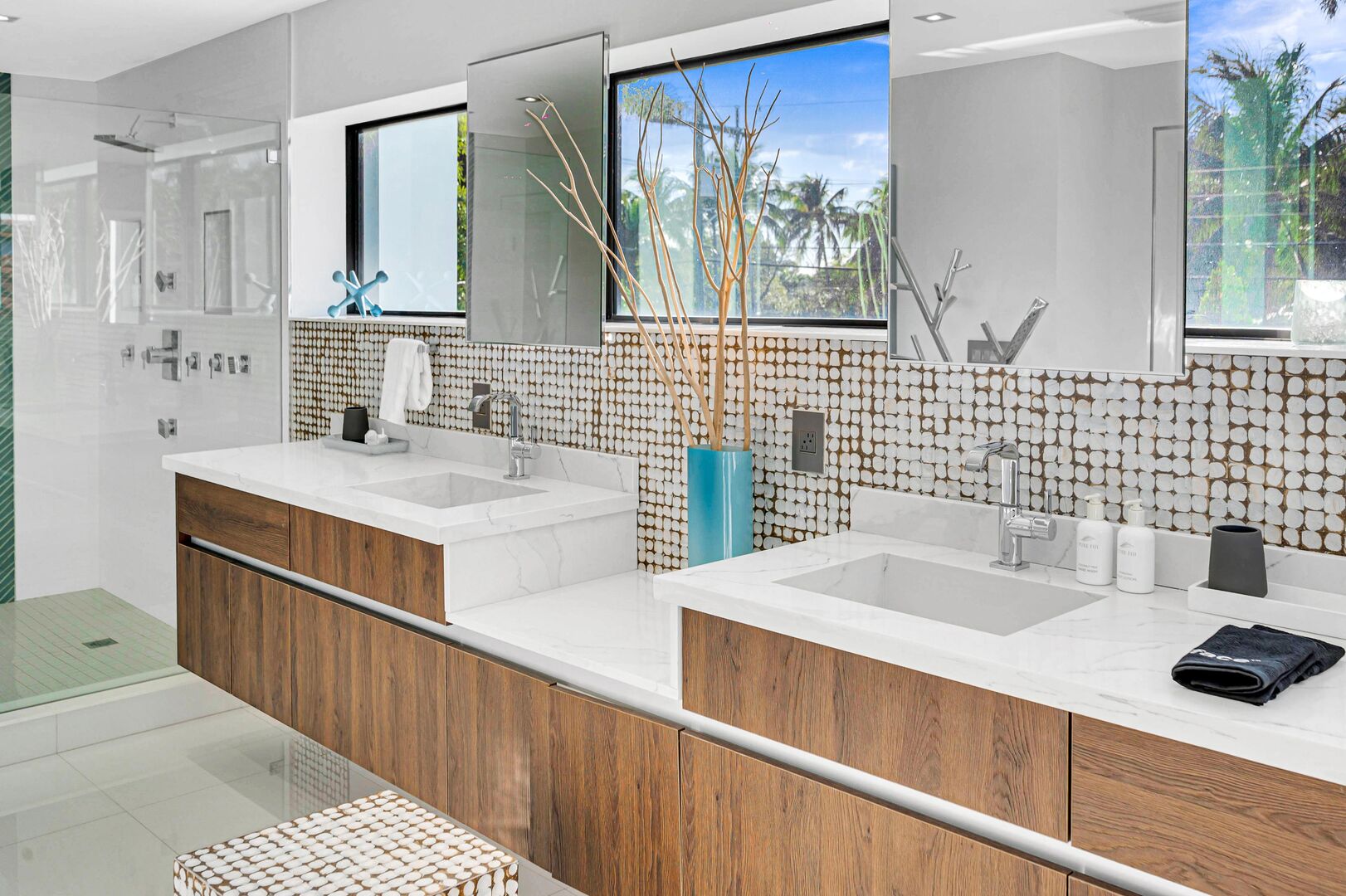 The primary bathroom filled with natural light features an oversized walk-in shower and a tub.