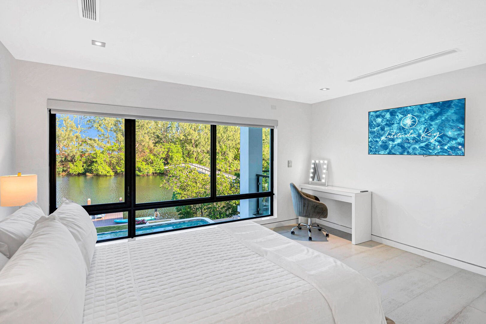 Bedroom three features a king size bed, panoramic waterfront views and a smart TV.