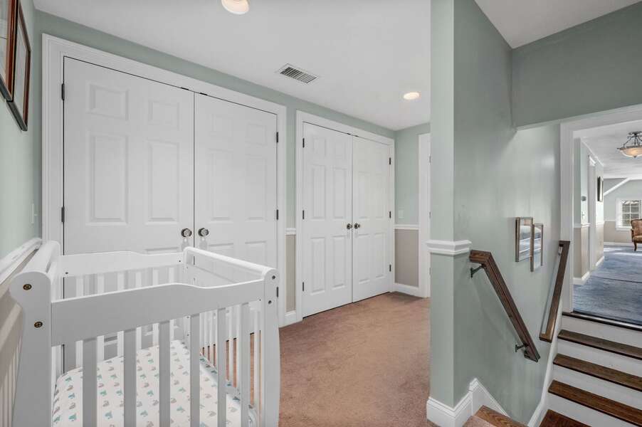 Additional full sized crib located in a nook outside of the Primary bedroom and near the secondary staircase leading down to the hallway near the kitchen - 92 Hoyt Road Harwich Port Cape Cod - Apricari - NEVR