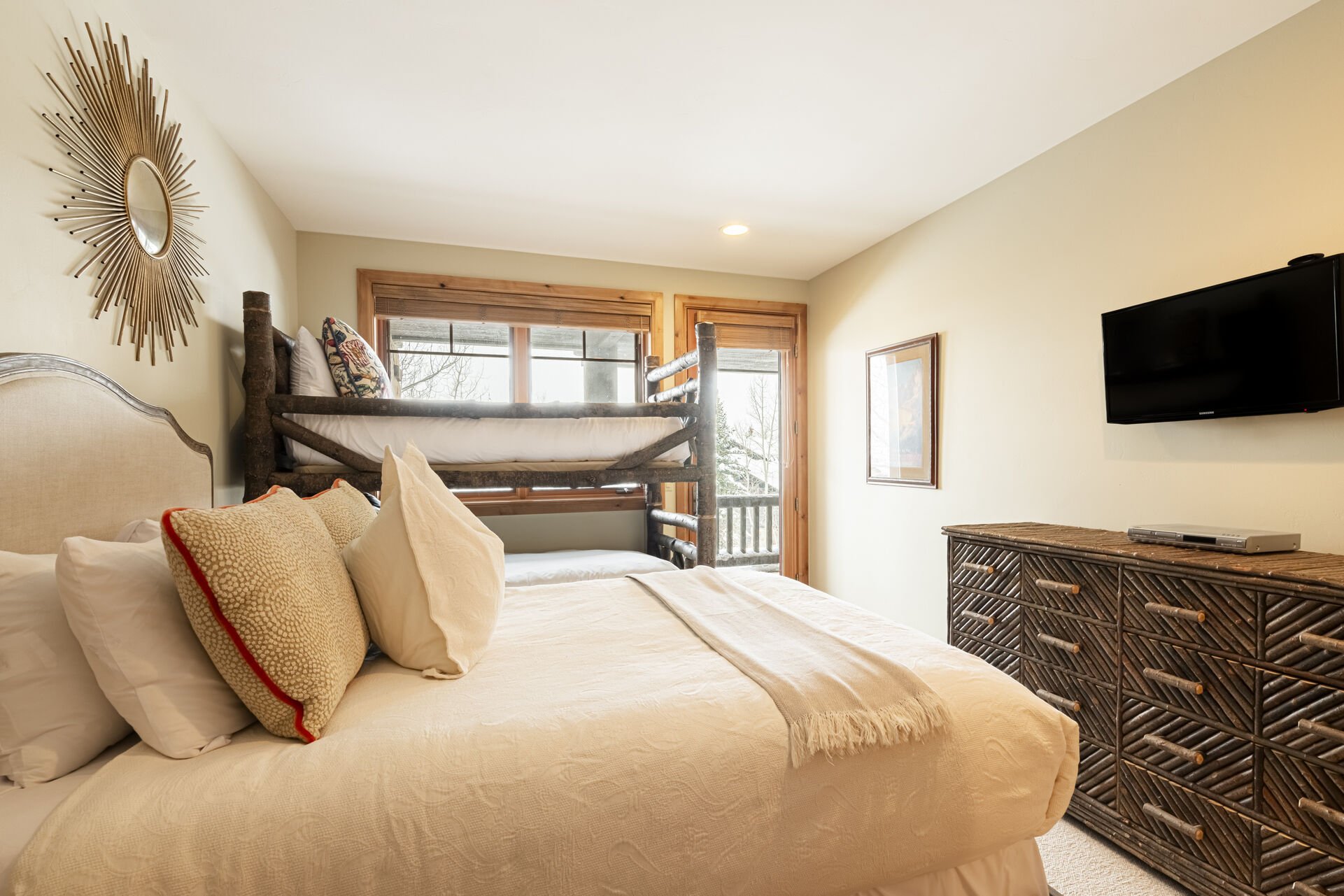 Bedroom 4 offers a queen bed, twin over twin bunk beds , a 32” Samsung TV, and deck access