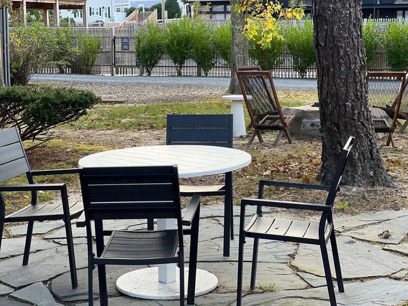 Outdoor dining table with firepit area beyond - 6 Manning Road Dennis Port Cape Cod - Sweet Retreat