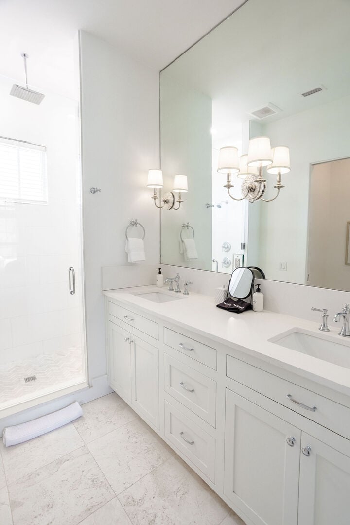Bathroom has dual sinks and large walk-in shower.