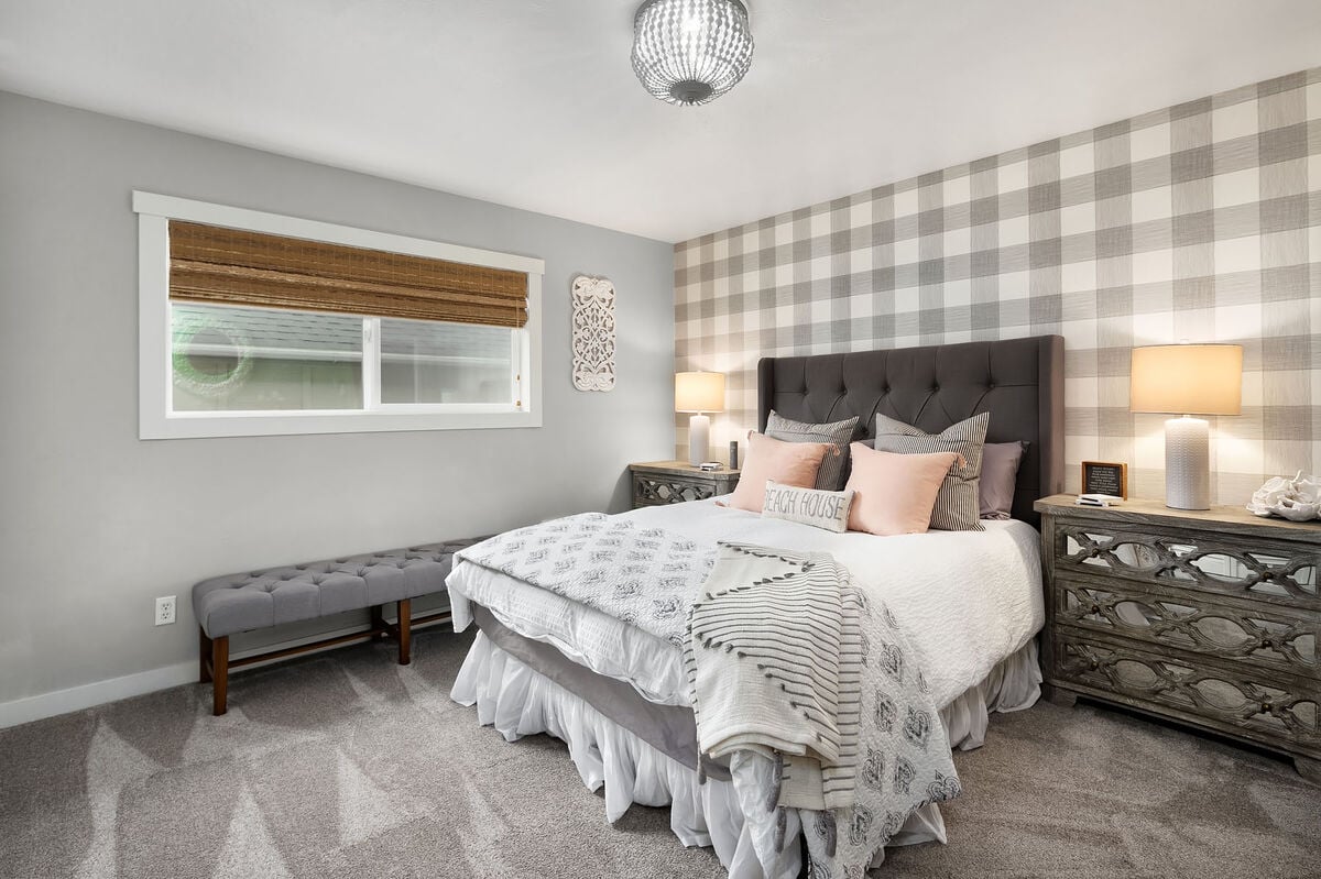 The generously-sized second bedroom has a luxurious queen bed with premium linens. There is plenty of storage and additional seating, plus a large window with blinds for privacy.