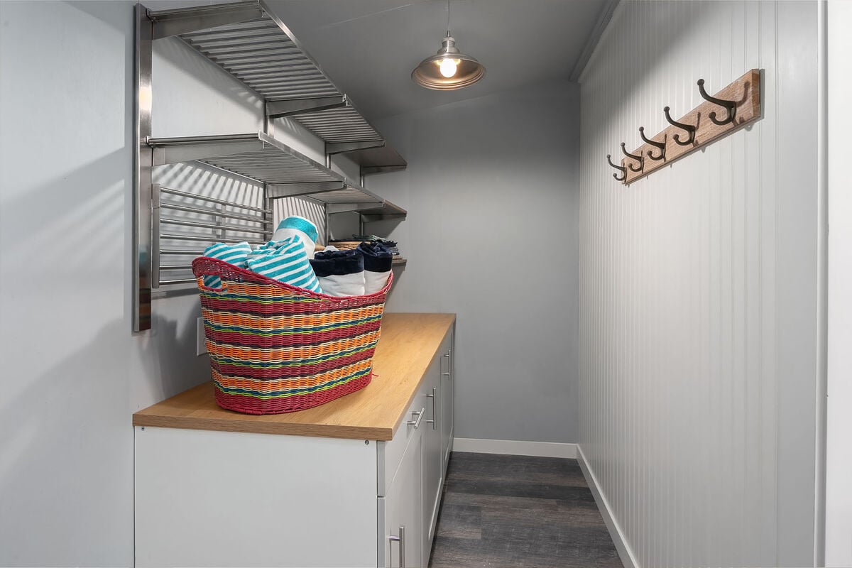 Laundry room offers storage of essentials such as beach towels and chairs.