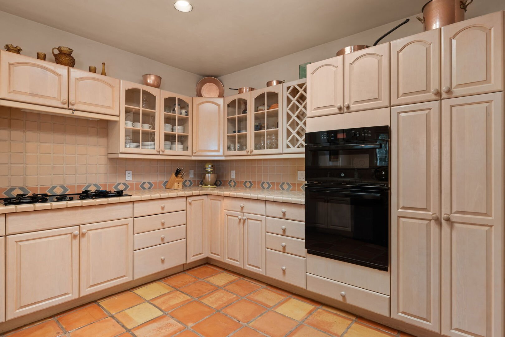 Prepare culinary delights in the well-equipped kitchen boasting ample counter space, a wine rack, built-in appliances, and a variety of kitchen essentials for your convenience.