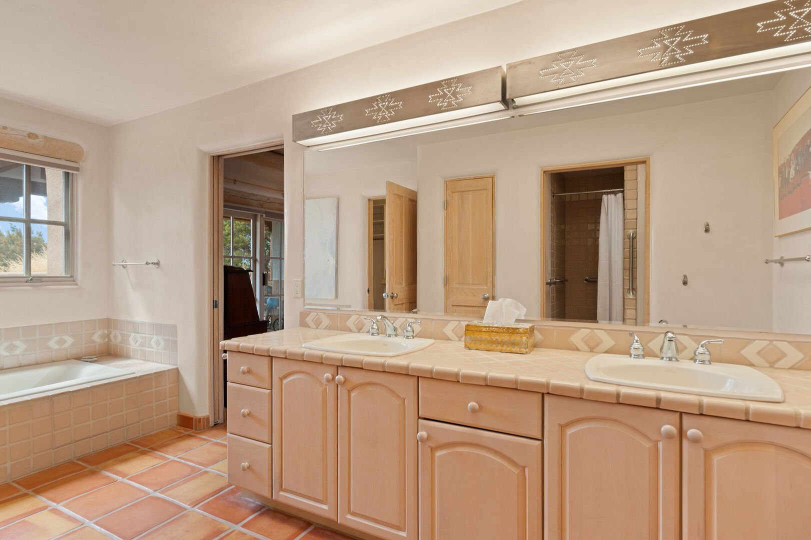 Primary bathroom with double vanities and a large tub