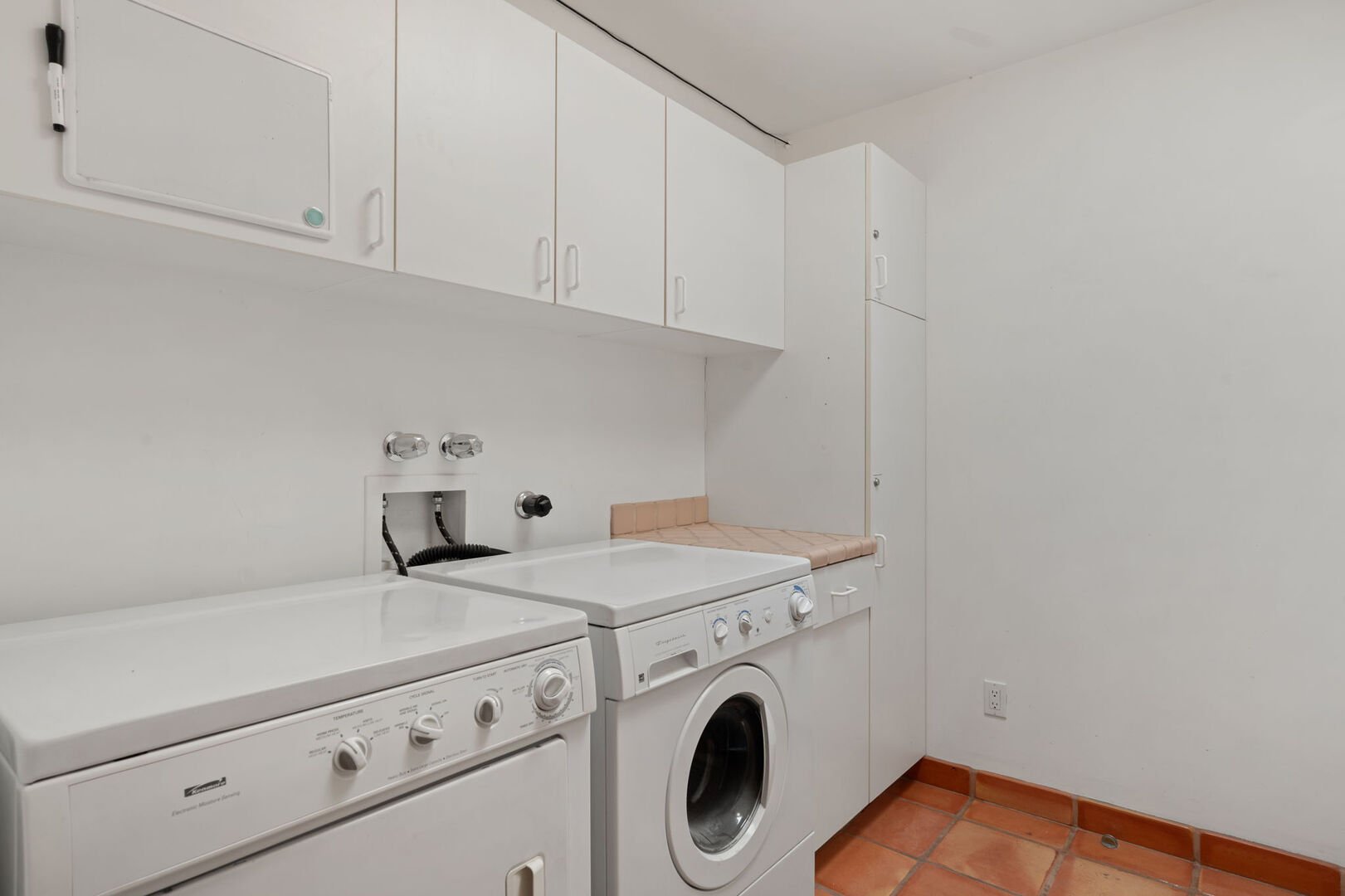 The laundry room is equipped with a washer and dryer, as well as ample cabinets for storing all your laundry essentials.