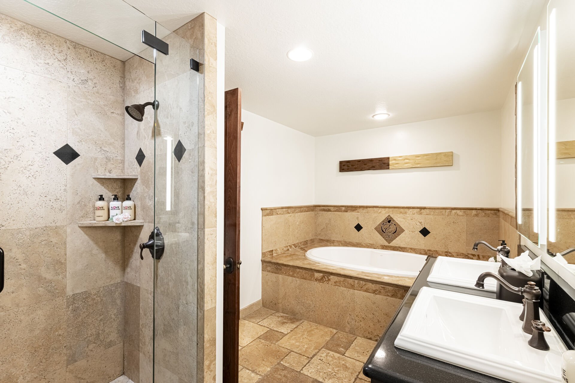 Master bathroom with two sinks, a shower, and a jetted tub