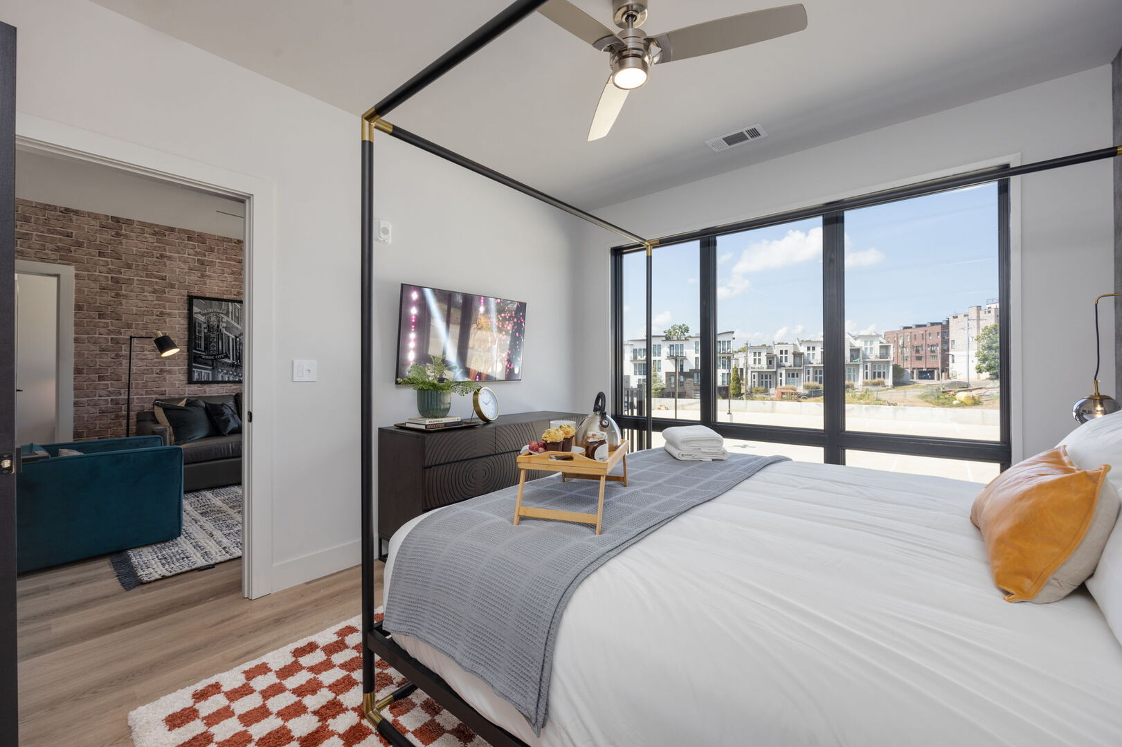 Unit 2: The primary bedroom features a spacious King bed and floor-to-ceiling windows. It's equipped with a Smart TV for entertainment, a luxurious en-suite bathroom for convenience, and a walk-in closet to accommodate all your belongings.