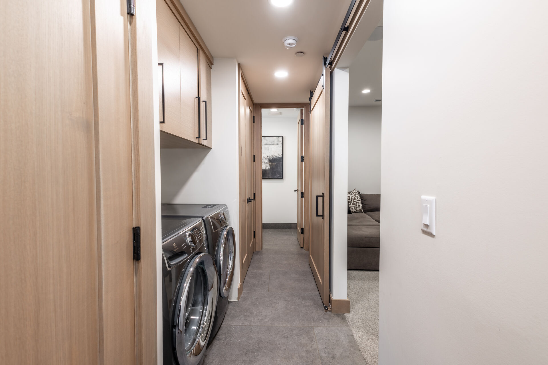 1st level hallway with full-size front load washer and dryer