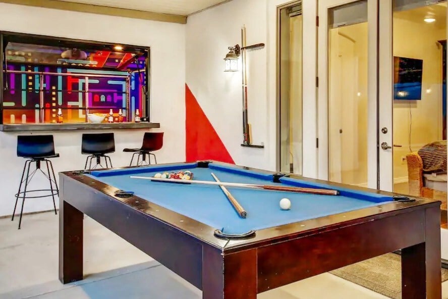 Pool table that is next to the bbq as well as brings the inside outside.