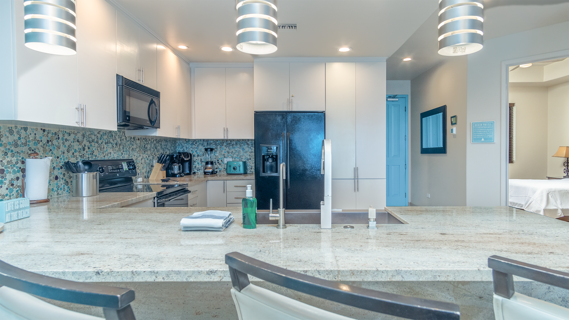 the kitchen counter has custom lighting, and raised seating