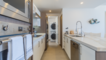 Pass through the kitchen to the washer and dryer