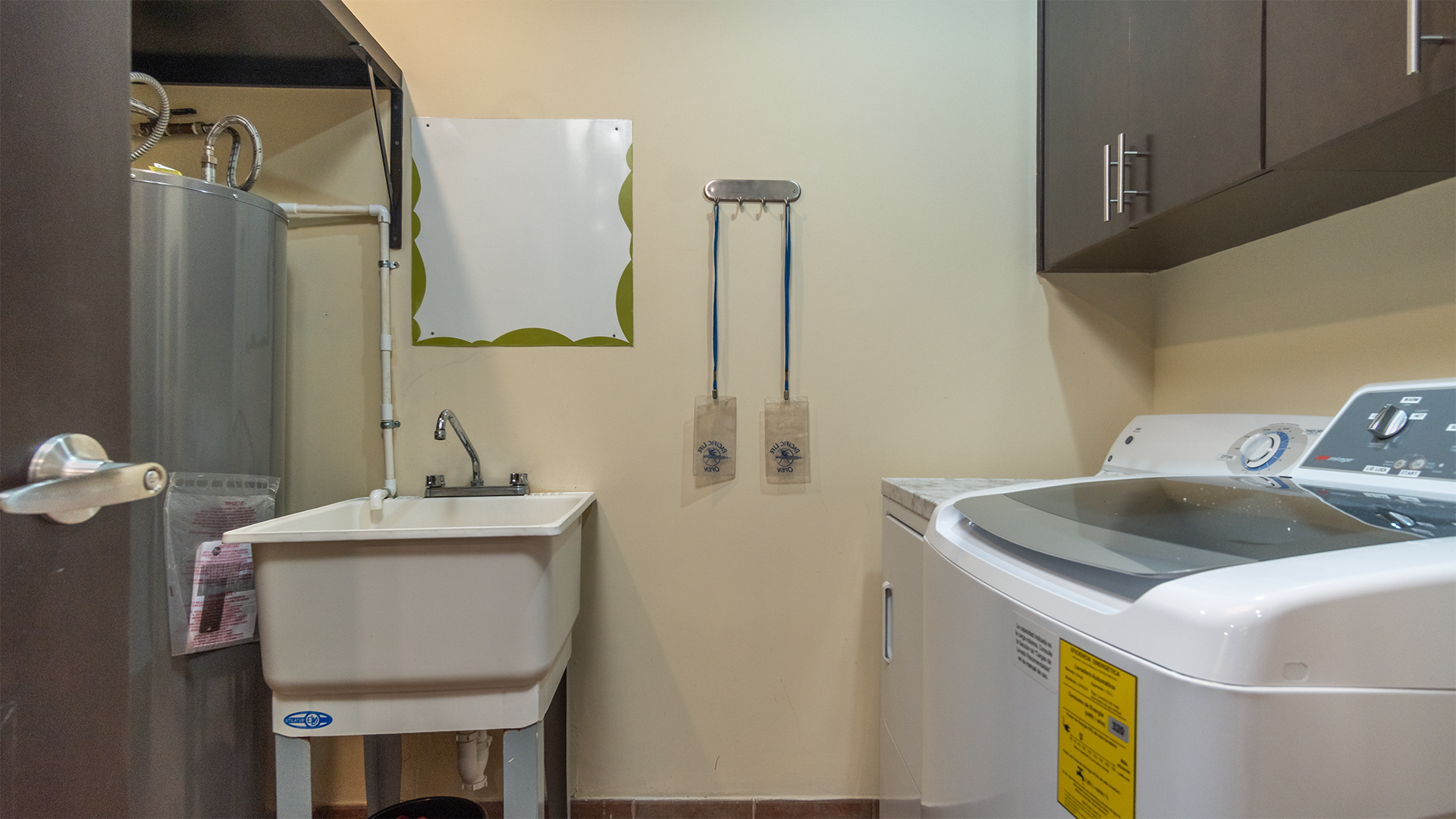 just off of the kitchen is the laundry room with sink, washer, and dryer