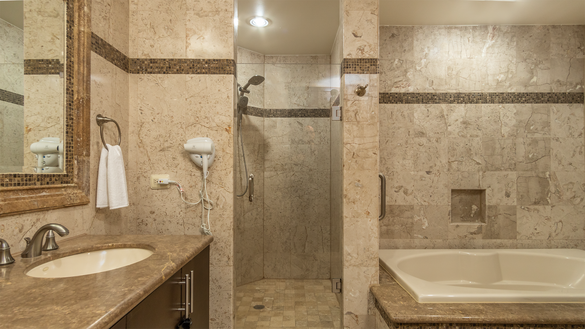 Great main bathroom with granite walls, shower, and large raised bathtub.