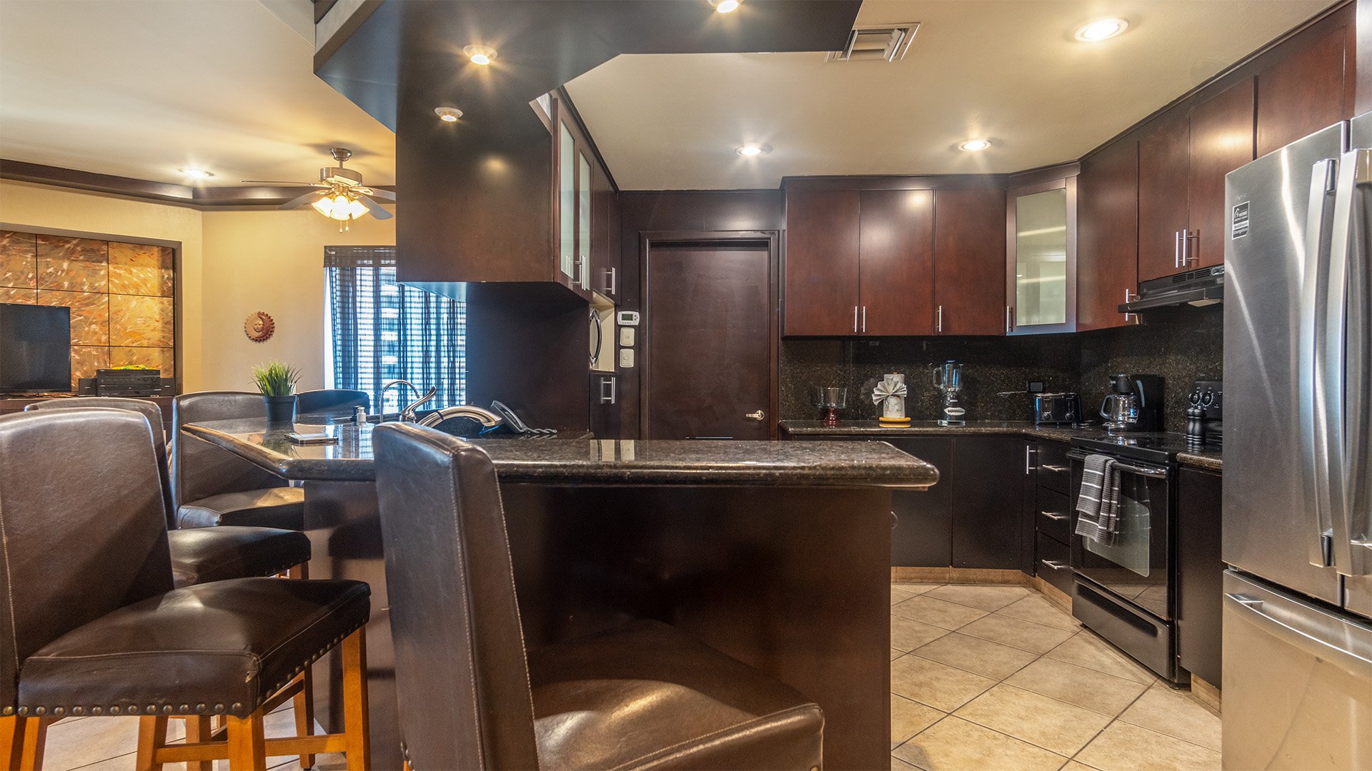 Dramatic with its dark granite and cabinets, the kitchen provides a spacious place to prepare meals.