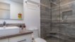 Hall bathroom with glass enclosed shower and vanity.