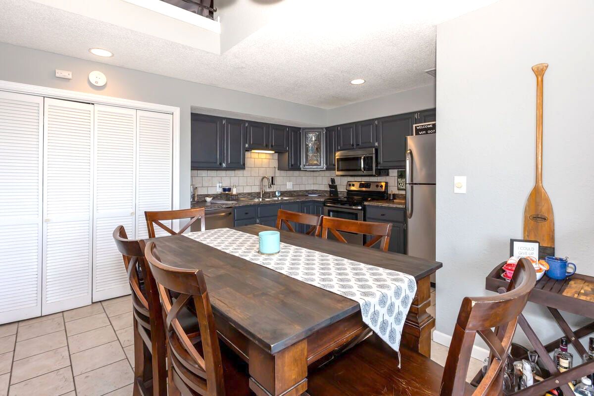 The modern kitchen features sleek stainless-steel appliances, dark cabinetry, and a stylish tile backsplash. Equipped with everything you need for cooking and dining, it's the perfect space for preparing meals while enjoying the comforts of home.