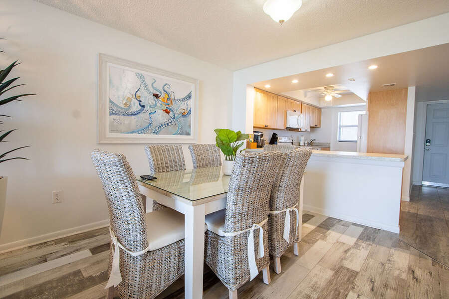 The charming dining area provides an elegant space with woven chairs and coastal-inspired decor.