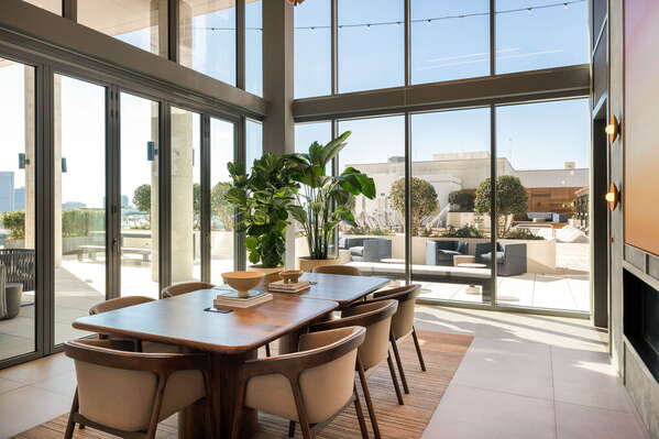 Private conference room with a streaming TV, bar, and wine fridge, offering views of the pool deck