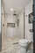 The master bathroom shower area is spacious, with elegant wave-patterned tiles that create a soothing and luxurious atmosphere. The shower is equipped with a rainfall shower-head, adding a touch of spa-like comfort.