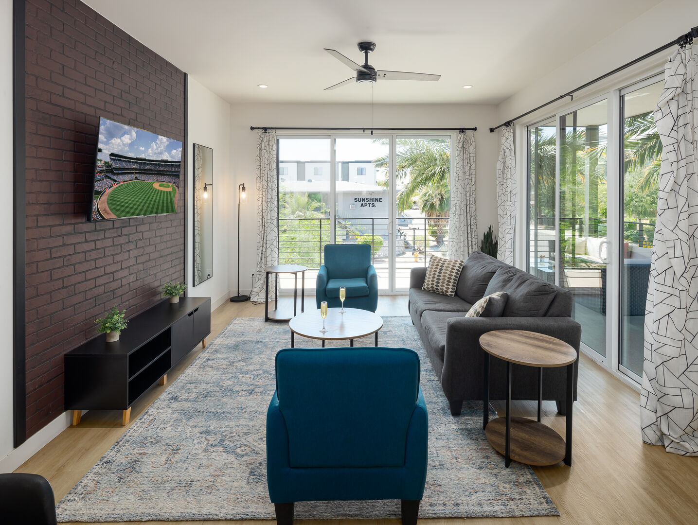 Unit 2 (1st Floor): Warm and inviting living room featuring a Smart TV for entertainment, and designer furnishings including a sleeper sofa that converts into a Queen Bed.