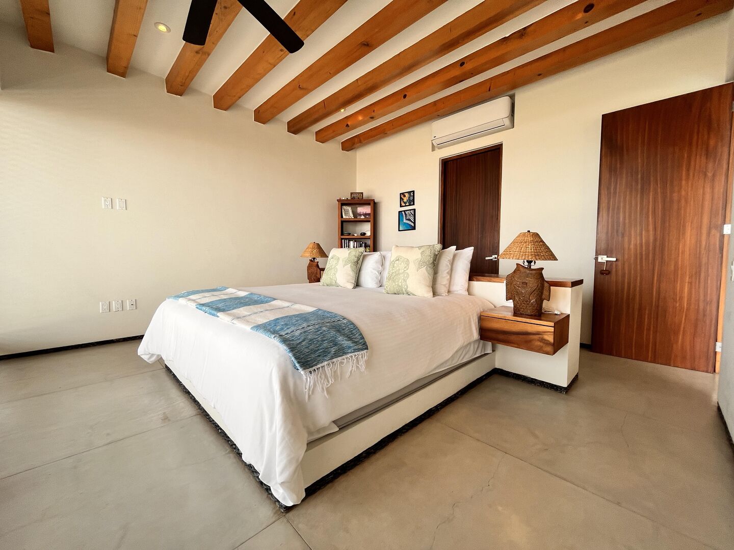 Rest in this inviting master suite, featuring warm wooden beams, elegant decor, and direct access to nature.