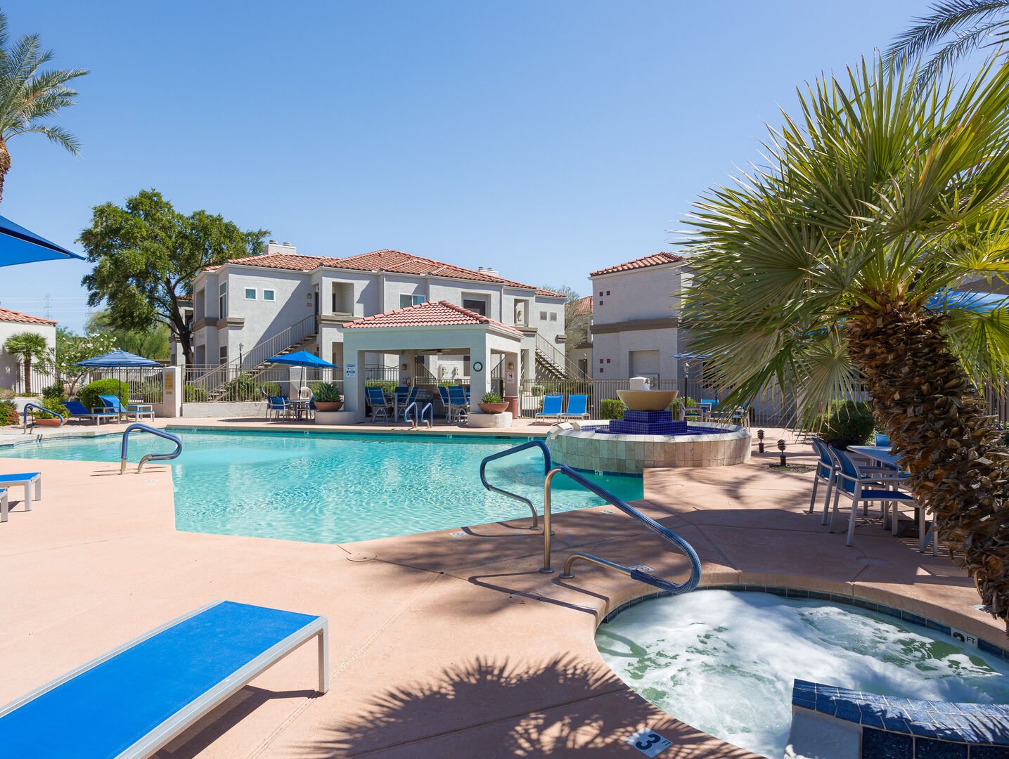 Enjoy the community pool area featuring a refreshing pool, relaxing spa, gas grills, outdoor dining tables with umbrellas, and plenty of sun loungers for the ultimate day of leisure.