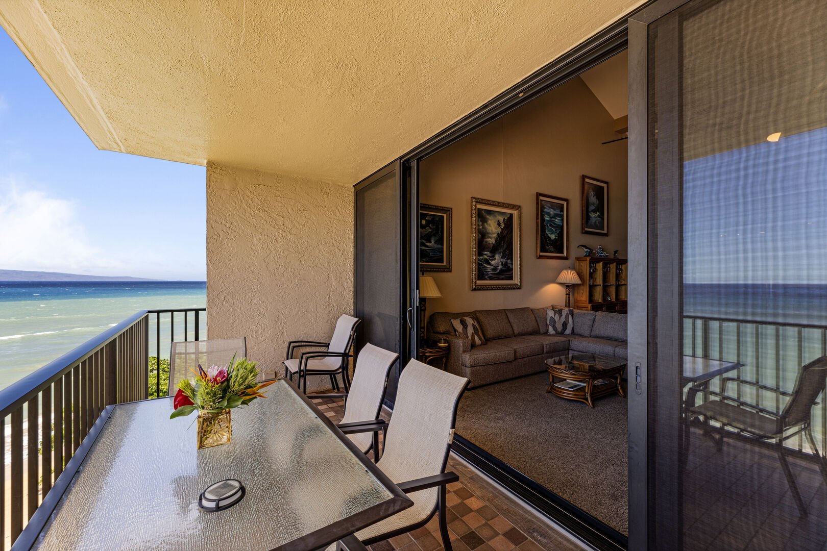 This bright and open living area features access to a private balcony with direct ocean views, offering a relaxing spot to unwind.