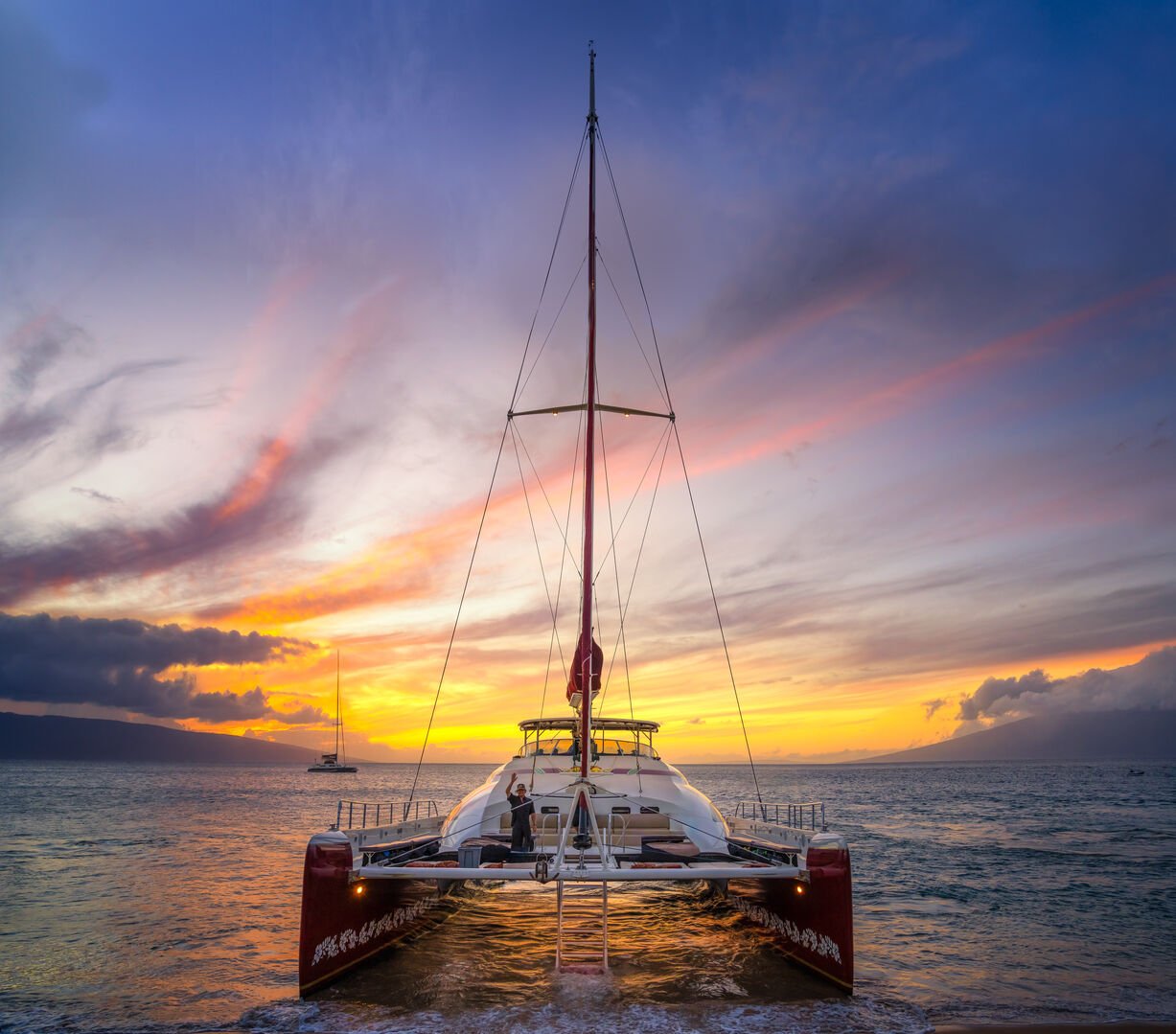 Set sail on a luxurious catamaran at sunset on Kaanapali Beach, enjoying vibrant skies and panoramic ocean views.