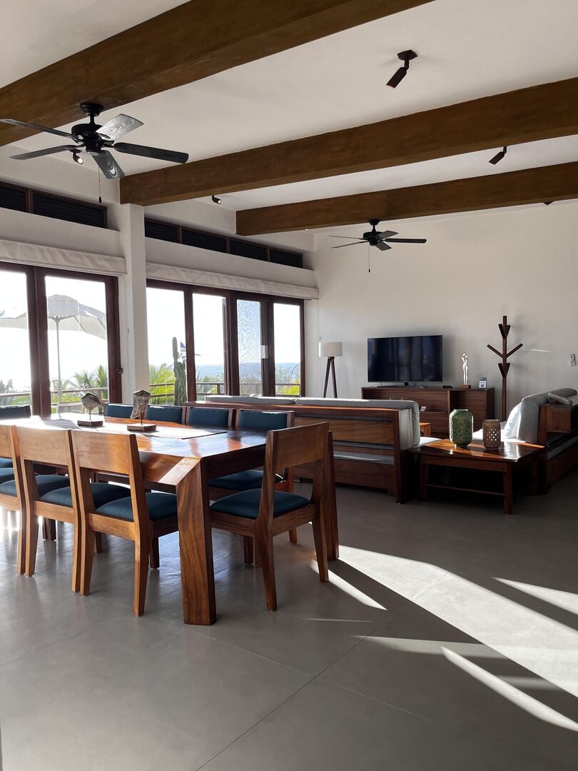 A fully equipped kitchen and dining area featuring sleek wood finishes and ocean-view seating for the perfect vacation meals.