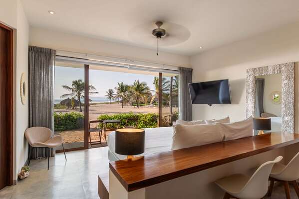 A spacious living area with stunning ocean views, modern furnishings, and a smooth transition to the outdoor lounge.