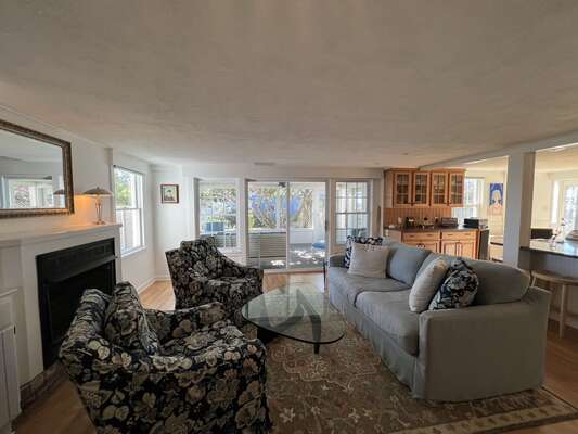 Living area with fireplace and access to the screened in porch.