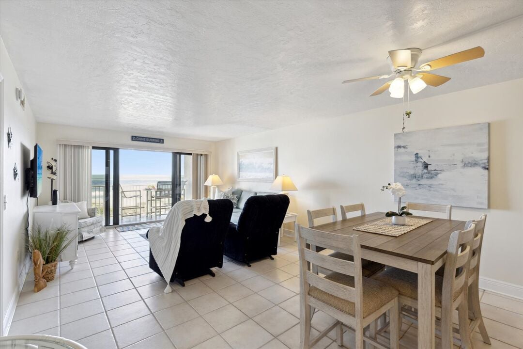Bright and inviting space with a dining table and comfortable seating, overlooking the Florida coastline