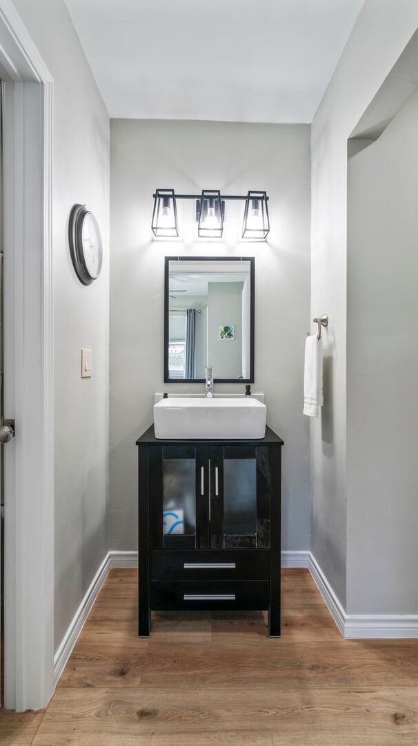 Sink and mirror in the hallway by the back bedroom.