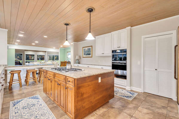 The expansive gourmet kitchen is a chef's paradise, boasting state-of-the-art appliances and ample seating for guests to gather and enjoy.