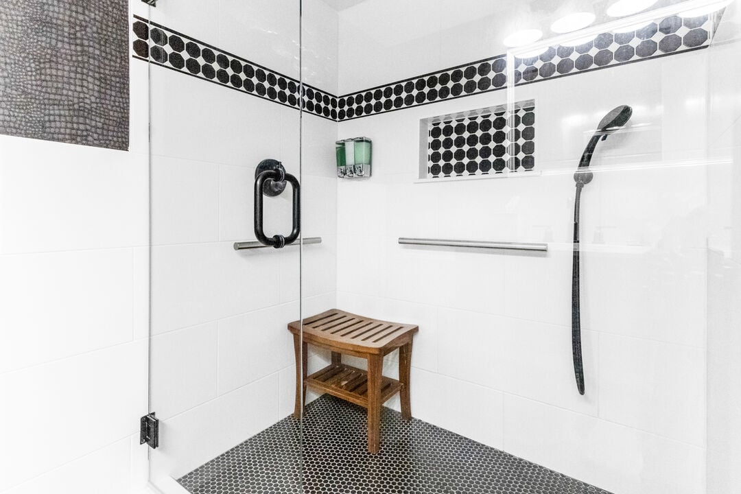 Spacious walk-in shower with a comfortable bench and accent tiles.