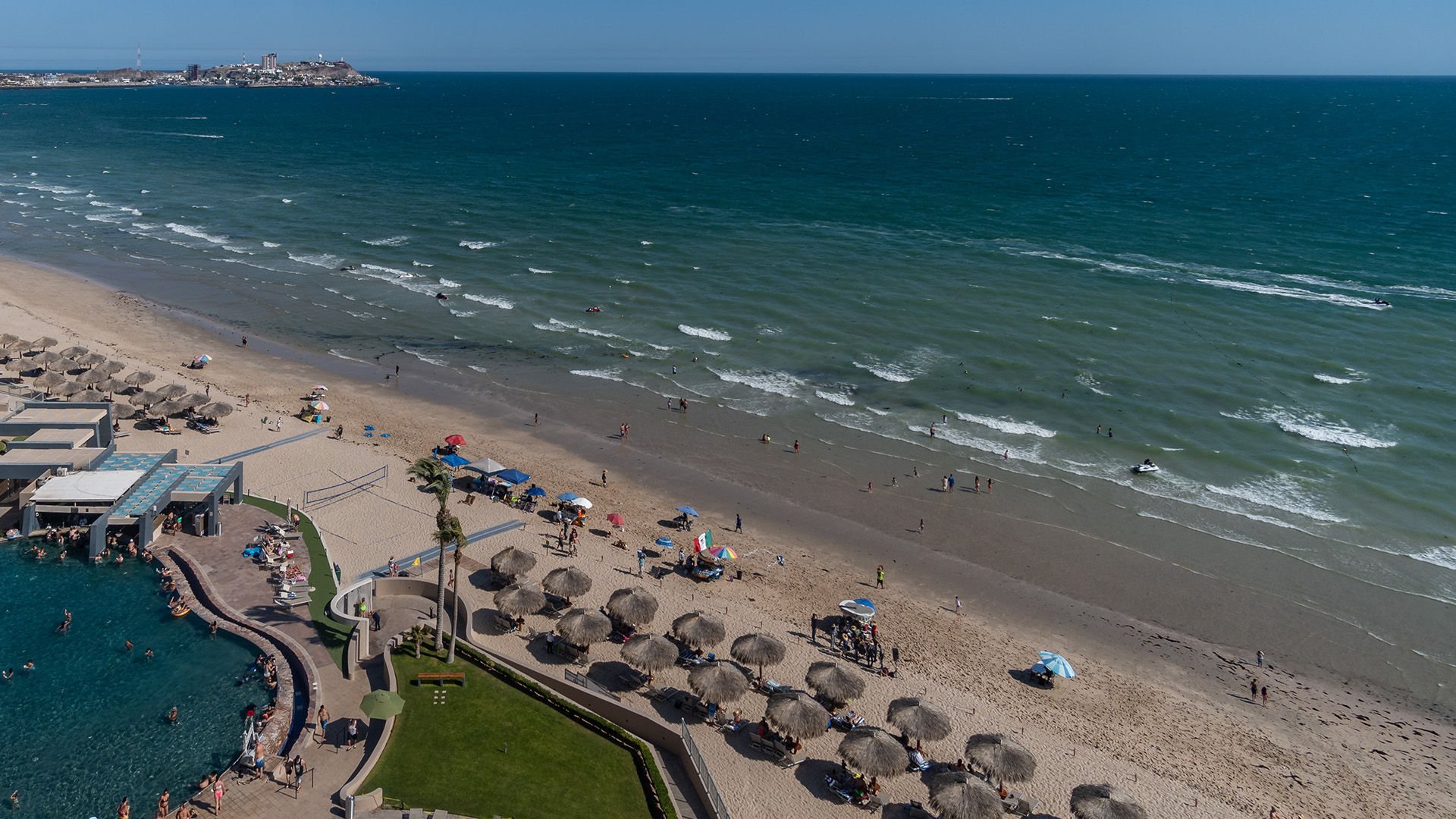 Wide view down to the beach. City skyline in the distance.