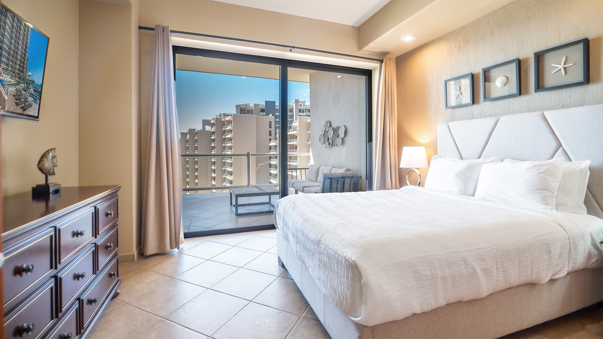 The second bedroom with  king bed, TV, and sofa area on terrace outside.