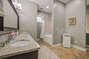A luxurious bathroom featuring a granite countertop, bright lighting, and modern amenities.